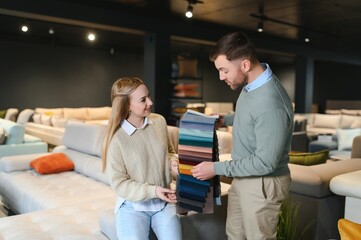 Couple choosing sofa in furniture store