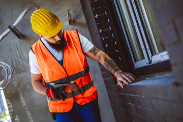 Portrait of successful man constructor wearing yellow helmet and safety yellow vest. Portrait of...