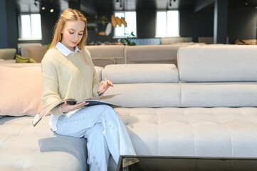 Woman designer at furniture store looking at textile swatch