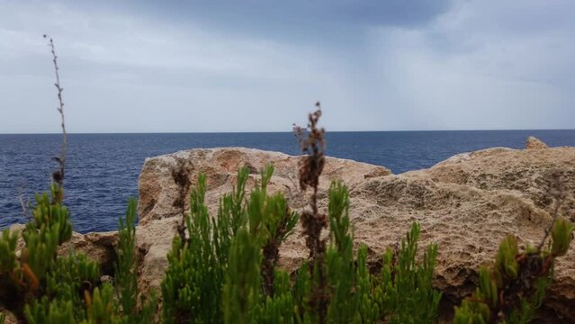 Blue mediterranean sea and rocky coast of Maltese island with Filfla uninhabited island in the distance. High quality 4k footage
