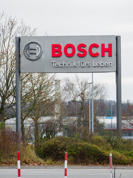 BOSCH sign in Homburg, Saarland, that's standing right next to the entrance of the Bosch Werk WEST with some of the buildings that have a striking red line across the whole front.