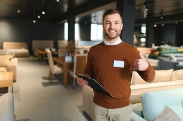 Confident salesman standing in furniture store exhibition center