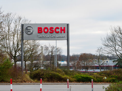 BOSCH sign in Homburg, Saarland, that's standing right next to the entrance of the Bosch Werk WEST with some of the buildings that have a striking red line across the whole front.