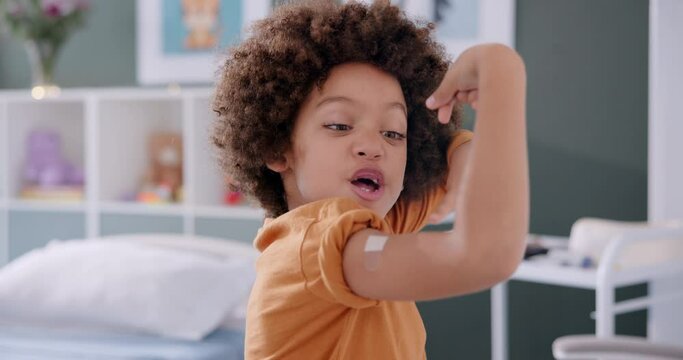 Healthcare, young boy and strong arm for vaccination with protection from virus and bacteria at hospital. Happy, child and bandage from flu shot or injection at clinic for healthy immune system