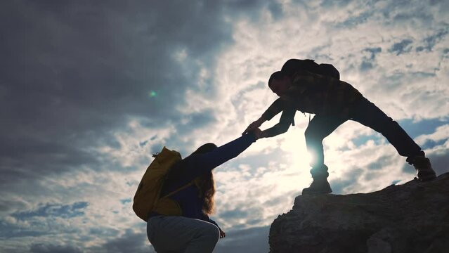 Teamwork in climb, reaching for climber. Climber giving hand for teamwork aid. High climb, trustful hand help. Climbing pair, teamwork hand assist. Motivation climb strong hand support. way to success