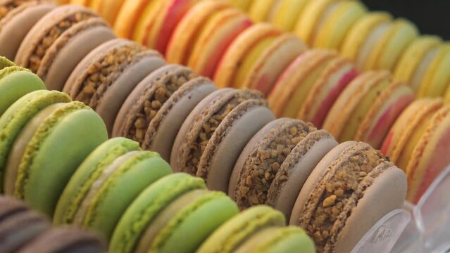 Display rows of colorful macaron almond cakes, popular French dessert. Variety of shades makes display case with this exquisite dessert attractive. Macarons French sweets for refined of dessert lovers