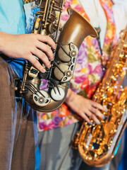 Musician playing saxophone on blurred background. Man with friends blow saxophone with the band for...