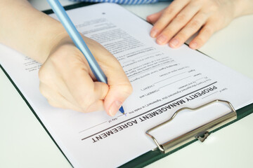 Property management agreement, hand fills out a document, signing lease, agent, real estate...