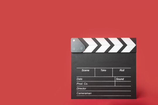 Cinema clapper board on a red background, copy space, video, industry, entertainment.