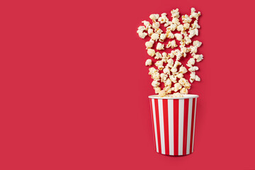 Popcorn box, theater film treat, classic salted snack striped,red background, copy space