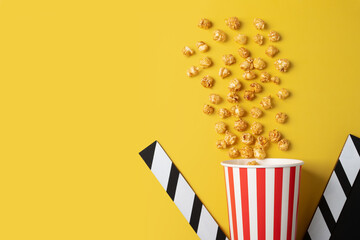 Popcorn caramel bucket and Cinema clapper board, cinematic entertainment box, tasty film snack,...