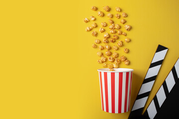 Popcorn caramel bucket and Cinema clapper board, movie theater snack, film production treat,...