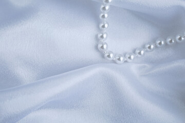 White pearls on a background of white silk