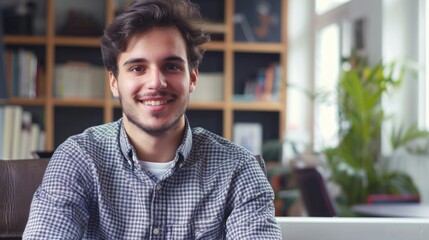 Fototapeta premium Young confident entrepreneur sitting in modern office smiling and looking at camera.