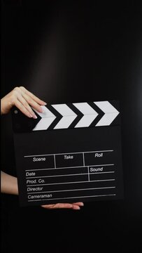 Hands with cinema clapper board, capturing the action, filmmaking in progress.