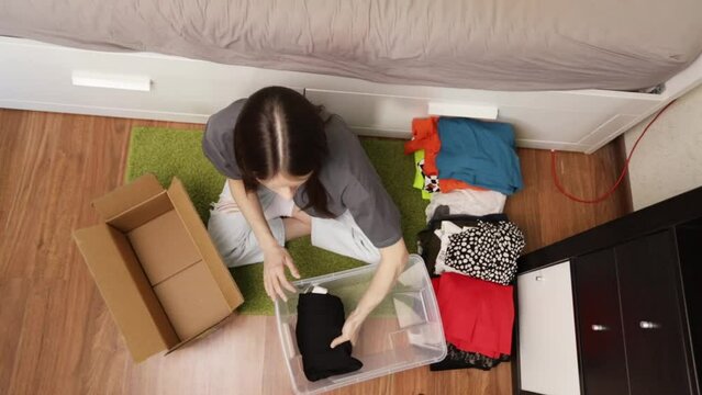 Teenage student packing things to move, carrying heavy boxes down dormitory hallways, campus departure, college relocation.