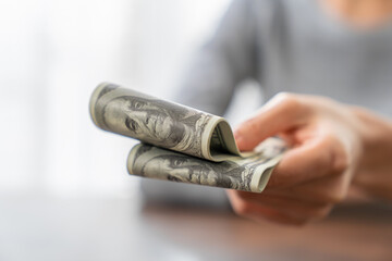 Woman hands holding dollar bills.