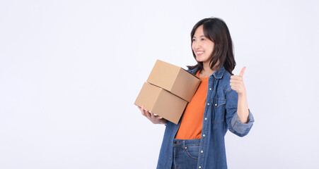 young asian woman wearing orange t-shirt and denim shirt holding parcel box isolated on white studio background, Delivery courier and shipping service concept.
