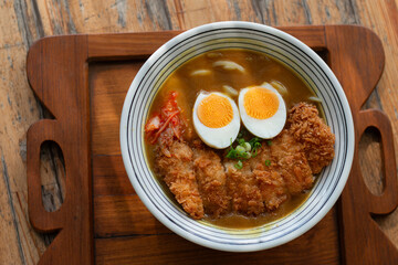 Japanese curry Udon with Tonkutsu serve on wood plate.