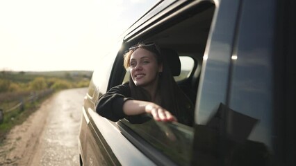 Smiling tourist on road trip adventure nature . tourist enjoys travel experience with hand out window. Scenic journey through nature during sunny drive. Happy tourist exploring world adventure trip.