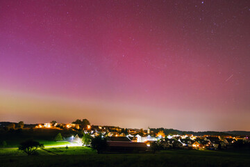 Rural Village in the Night under faint Red Sky from Aurora