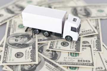 White toy truck lie on dollars, space for text.