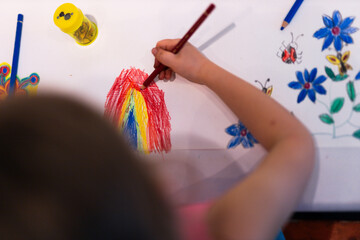 Child girl draws with colored pencils