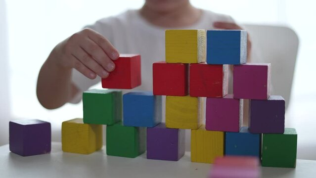Children building with blocks home. Children improves creativity and coordination. Building block towers encourages learning sharing. Children play with colorful blocks exploring education at home.