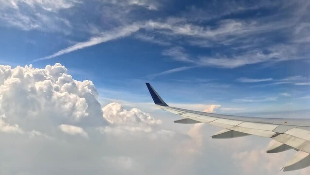 Beautiful clouds and airplane wings from the window with beautiful blue sky
