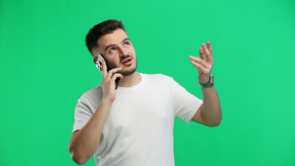 Man, close-up, on a green background, using a phone