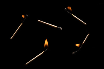 Lit falling match on a black background.