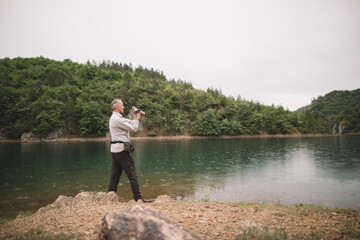 Grey hair fisherman casts his line