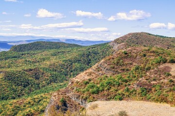 Fototapeta premium This stunning landscape features a beautiful mix of rolling hills, lush forests, and a serene blue sky. The scene is perfect for a relaxing getaway or an adventurous hike. Kiketi, Georgia.