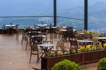 Beautiful views from above, tables in a cafe in the mountains and a panoramic view of the city, public places in Turkey, on a sunny summer day