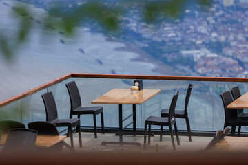 Beautiful views from above, tables in a cafe in the mountains and a panoramic view of the city, public places in Turkey, on a sunny summer day