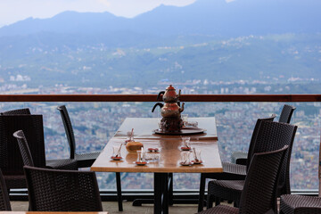 Beautiful views from above, tables in a cafe in the mountains and a panoramic view of the city, public places in Turkey, on a sunny summer day