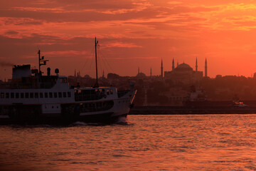 Fototapeta premium Orange sky at sunset in the evening. Silhouette and outlines of the buildings. Evening views of buildings of the city of Istanbul.