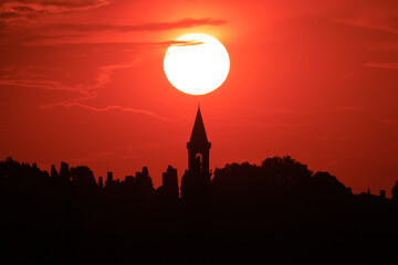 Fototapeta premium Orange sky at sunset in the evening. Silhouette and outlines of the buildings. Evening views of buildings of the city of Istanbul.