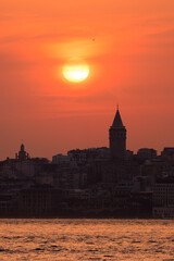 Obraz premium Orange sky at sunset in the evening. Silhouette and outlines of the buildings. Evening views of buildings of the city of Istanbul.