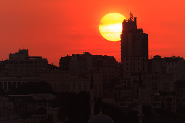 Orange sky at sunset in the evening. Silhouette and outlines of the buildings. Evening views of...