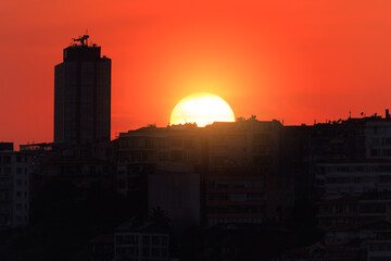 Orange sky at sunset in the evening. Silhouette and outlines of the buildings. Evening views of...