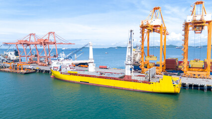 Fototapeta premium Crane loading box container to cargo ship at commercial dock port. Shipyard Cargo Container Sea Port Freight forwarding service logistics and transportation. International Shipping 