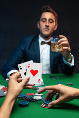 Close up view of women hand's with playing cards and chips at green casino table with poker player.