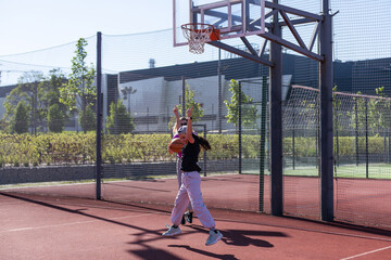 Fototapeta premium Mother and daughter playing basketball.