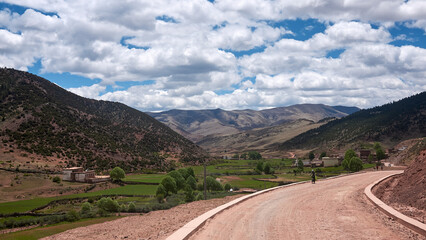 crops field and road on red soil in mountains in eastern tibet