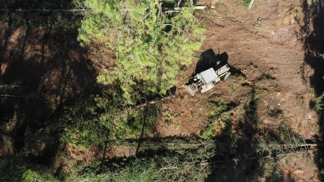 Aerial video above a tactor pulling a tree in Ein Shosfit National Park, Israel