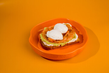 A sandwich with avocado and cheese is on a plate