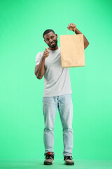 A man, full-length, on a green background, with bags