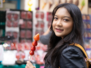 Travel lifestyle urban tourist, young girl with Strawberry candy in Osaka Japan.