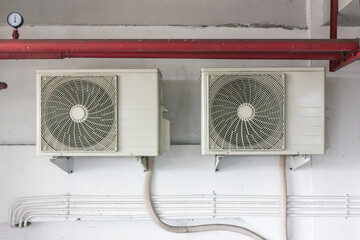 Two Air conditioner compressor installed on wall outside of the building